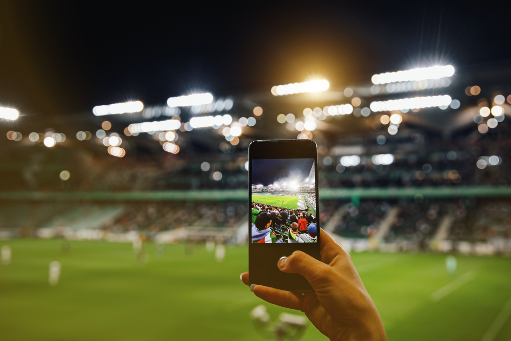 Fan,Hand,With,Smartphone,Photographing,Football,Match.,Using,Mobile,Phone