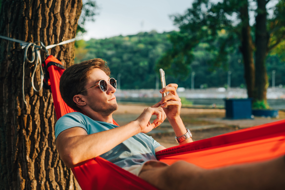 Handsome,Young,Man,In,Sunglasses,Lying,At,Sunset,In,A