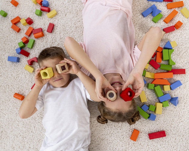 top-view-non-binary-kids-playing-with-colorful-game_23-2148779611